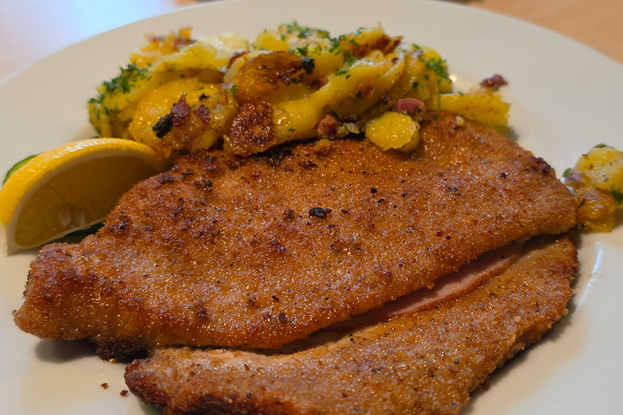 Paniertes Schnitzel mit Bratkartoffeln und Zitrone