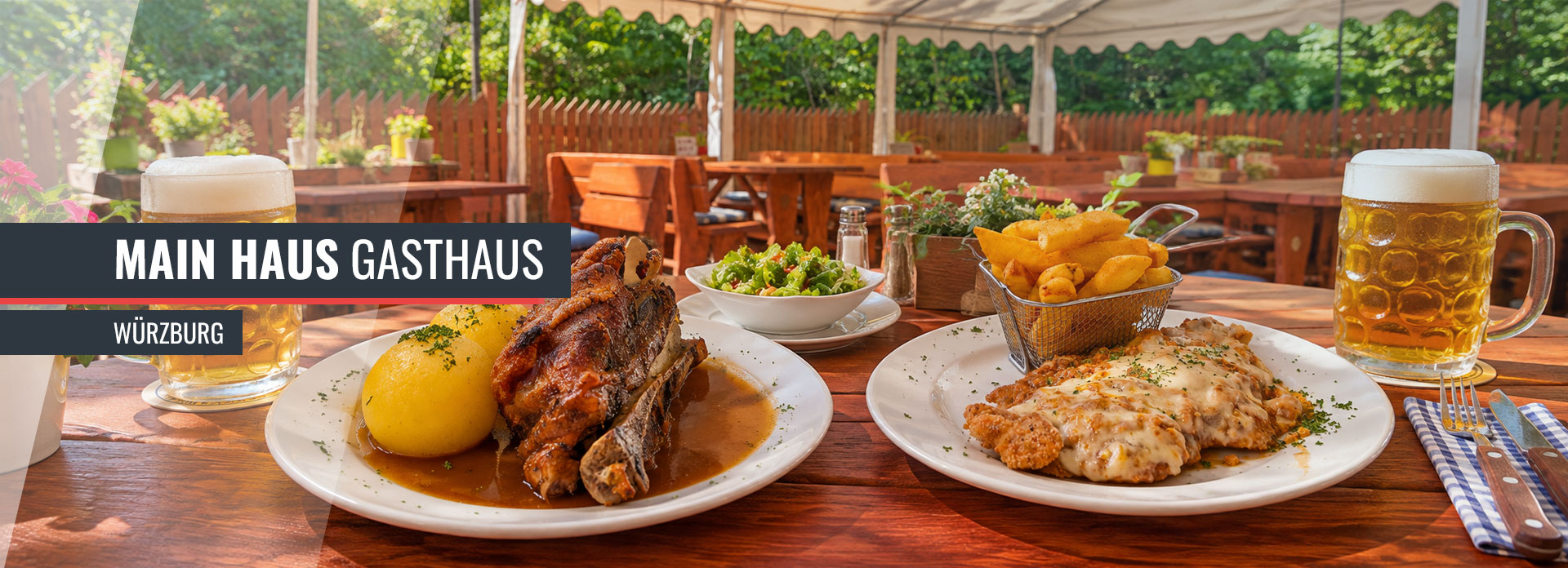 Schäufele mit Klößen und Schnitzel mit Pommes auf einem gedeckten Tisch im Außenbereich des Main Hauses in Würzburg