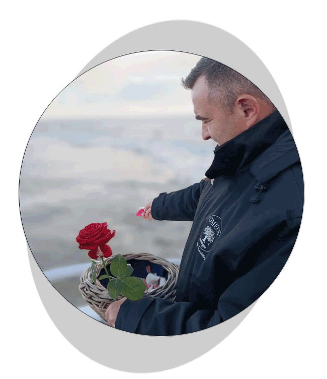 Mitarbeiter von OMEGA Bestattungen mit Rosen bei einer Seebestattung