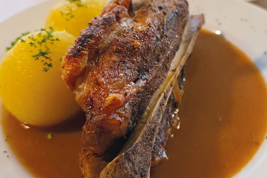 Fleischgericht mit Kartoffelklößen und Soße im Main Haus